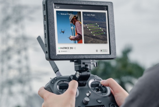 eine Person hält eine Drohnensteuerung mit zusätzlichem Bildschirm in der Hand