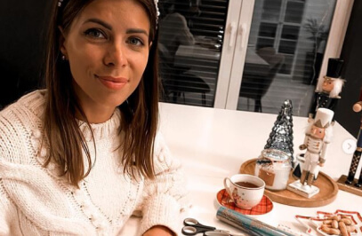 eine Frau macht ein Selfie an einem Tisch mit Weihnachtsdekoration darauf