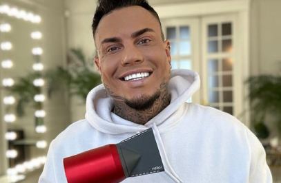 lächelnder Mann hält Haartrockner