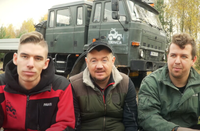 drei Männer sitzen vor einem Geländewagen