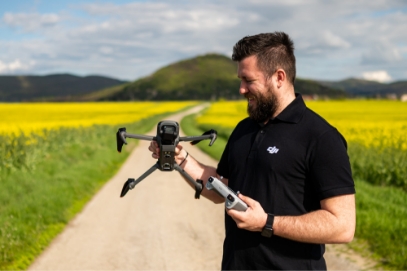 ein Mann steht draußen und hält eine Drohne