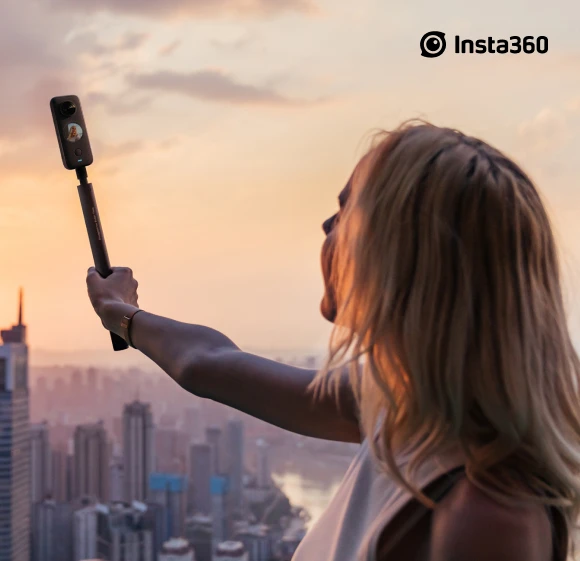 Junge Frau macht ein Selfie vor der Kulisse einer Großstadt